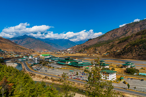 Landscape view of the Bhutan Airport building with the runway in the middle of mountains