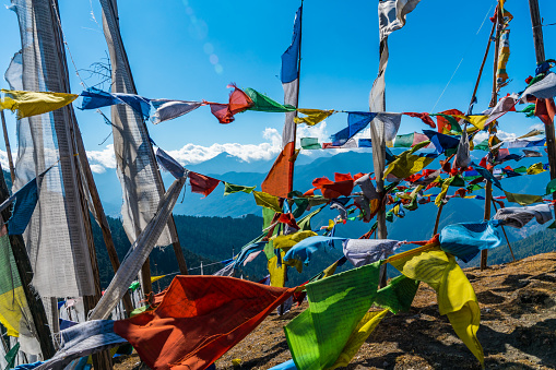 Himalayan valley view through flying prayer flags at Chele La Pass in Bhutan