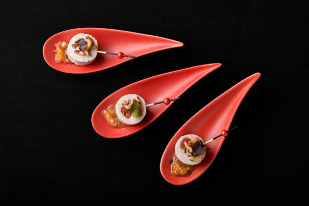 goose liver pate, foie gras, served on black stone in japanese red spoons. paste served with jam and nuts. fusion food concept, low key, copy space. - foie gras salt luxury restaurant photos et images de collection