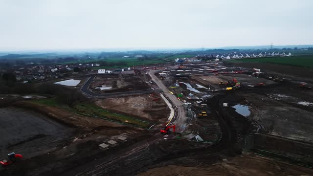 Slow establishing shot of a large construction site in the Scottish countryside