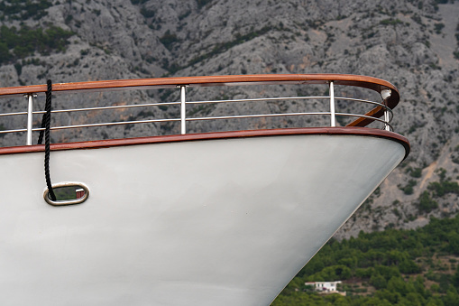 shot of the front of the yacht in the summer with mountains in the background