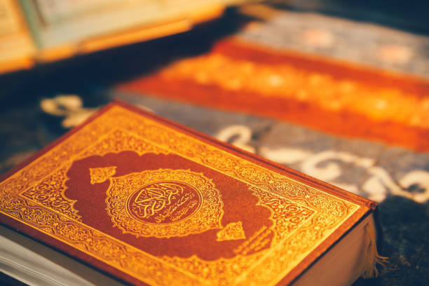 istock Red Quran with golden light with copy space. 2103476011