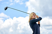 Portrait of a beautiful woman playing golf on a green field outdoors background. The concept of golf, the pursuit of excellence, personal excellence, royal sport.