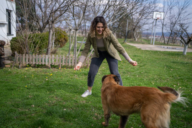 Young woman playing with her dog in backyard