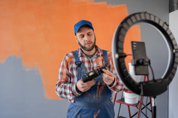 istock Blogger builder handyman recording live broadcast on social networks, talking about electric screwdriver for home renovation 2103487162