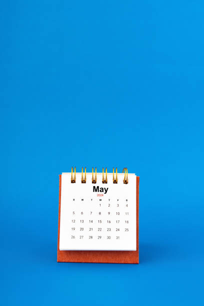 istock May 2024 white desk calendar on blue background. 2103497232