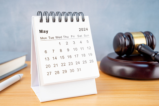 Desk calendar for May 2024 and judge's gavel on the worktable.