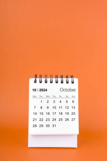 istock Vertical of October 2024 table calendar on orange background. 2103497235