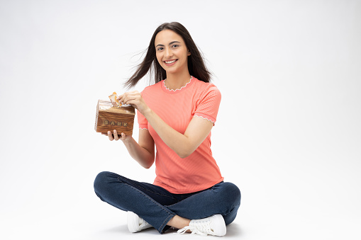 Full length body size photo of young girl sitting on floor wearing jeans denim pink t-shirt footwear isolated over white background