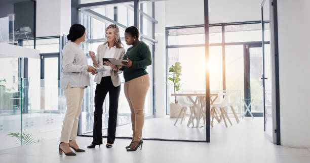 istock Women, tablet and discussion for teamwork, diversity or office coaching or mentor. Company, workspace and technology for web design or internship with employees at creative business startup or career 2103513657