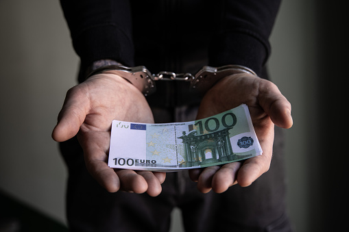 Man arrested holding 100 euros.