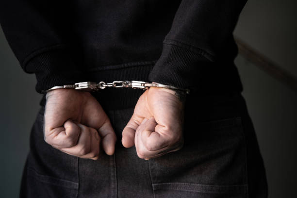 istock Arrested man with cuffed hands in the corridor. 2103527306