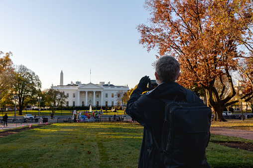 Tourists taking pictures of the White House.  Using mobile phone to capture  the iconic symbol of American democracy , Washington DC