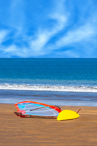 A colourful windsurfing board and sail on a sandy beach in El Medano, Tenerife, Spain.
