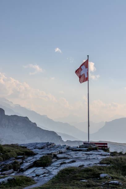 istock Swiss flag waving with Mountains background 2103544677
