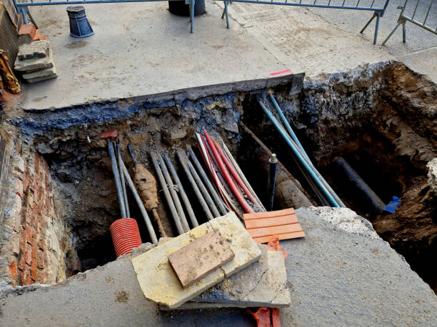 istock laying high voltage cables to ground. Excavation meter deep in the ground, black plastic coated strong cable wires. in case of danger of electric shock. connecting the connection to new house. network 2103563347
