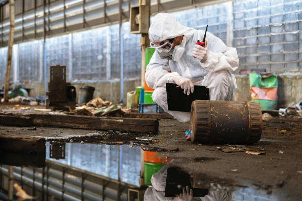 istock man in a white suit is looking at a barrel with a clipboard 2103608674