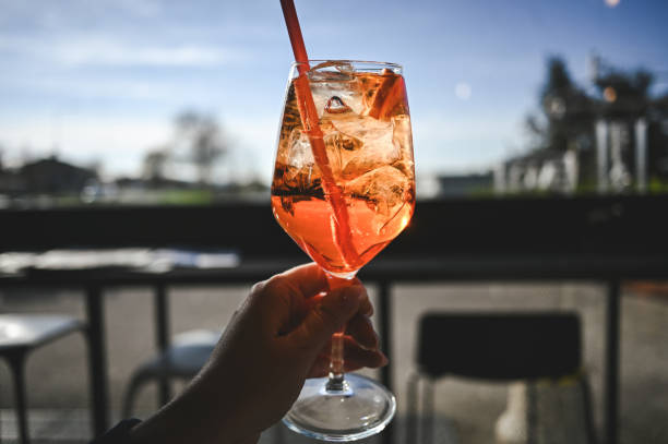 istock wine glass with orange color cocktail in a hand. 2103619255