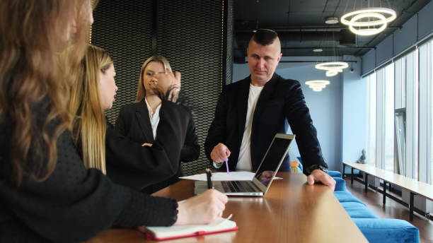 istock Office workers in formal suits discuss project at desk 2103619805