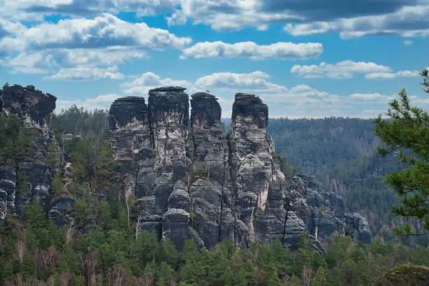 Rugged rocks on the Basteibridge. Wide view over trees and mountains. National park in Germany