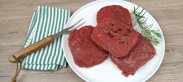 istock Raw chopped steaks, on a plate. Close-up. 2103632943