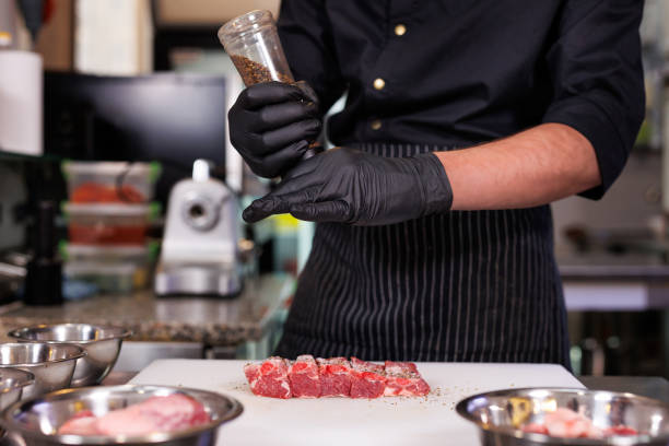 istock Chef cuts pork ribs, salts them and peppers them in the restaurant kitchen. 2103662152
