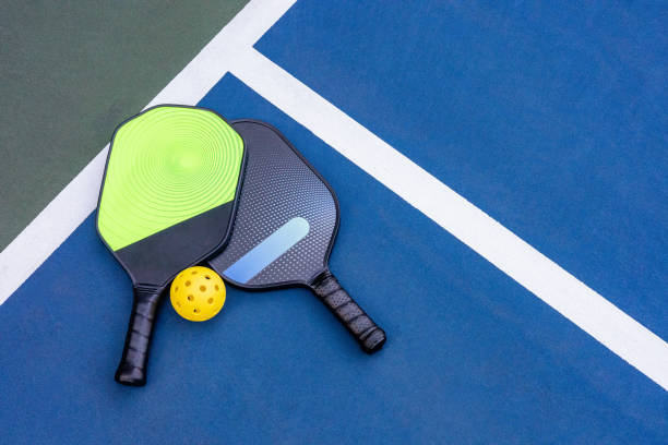 istock Pickleball Racquet's on blue court 2103672497