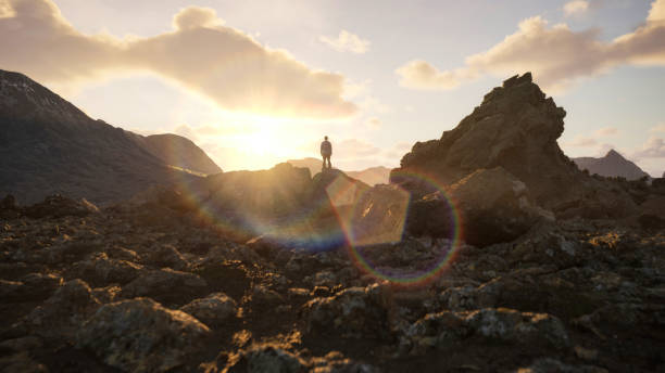 istock Adventurous Man Hiker on a rocky, rugged peak taking in view. Sunny with clouds in the sky. 2103677667