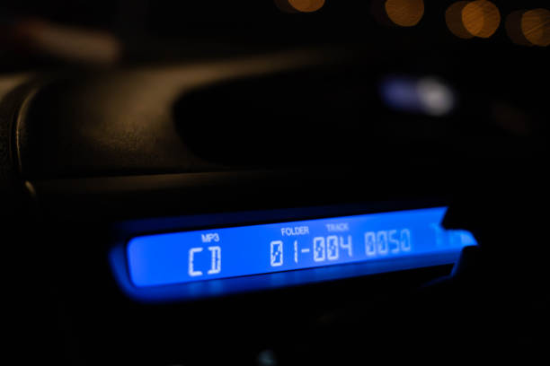 Audio system, dashboard and CD in modern cars light at night.
