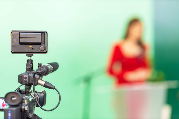 istock Filming media event or press conference with a video or television camera. Public speaking concept with copy space. 2103729909