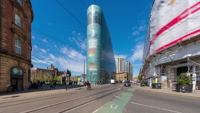 Road traffic with blue sky and moving clouds in the city centre of Manchester, England - 4k time lapse