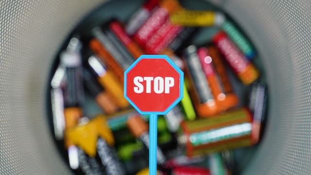 Throw used batteries into the trash. Overflowing used batteries in office garbage bin. Stop pollution by batteries