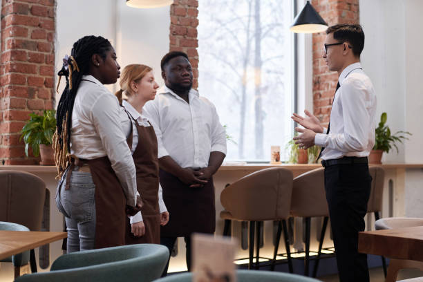 istock Restaurant Manager Talking To Waiting Staff 2103778588