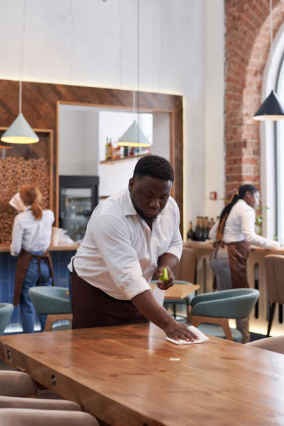 istock Black Man Cleaning Table In Modern Cafe 2103779099