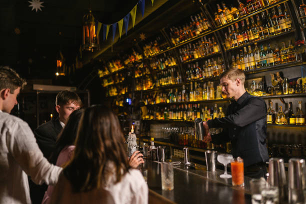 istock Pub guests supervise bartender making cocktails by counter 2103779619