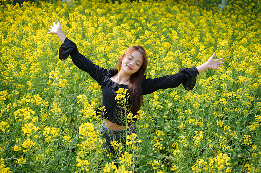 Female tourist in a sea of ​​yellow flowers