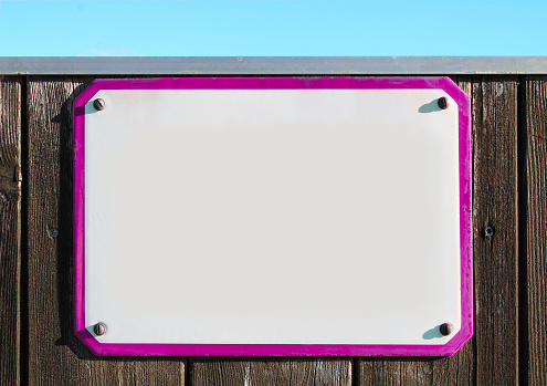 collage, enamel, metal or pottery sign on a rustic wooden wall. pink frame, under a bright blue sky. the sun is shining, rectangular stone slab with copy space to write in retro style for cards. fastened with four screws