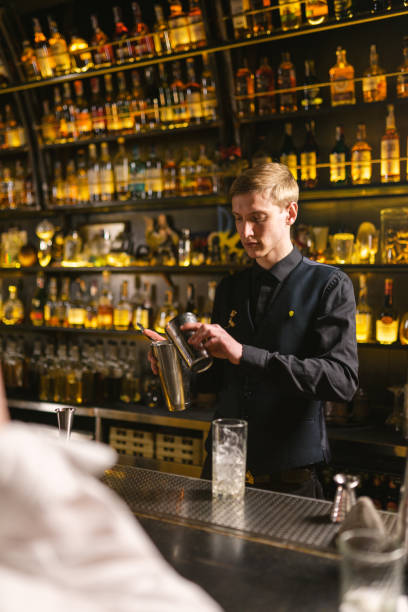 istock Focused bartender makes cocktails with aluminum utensils 2103820357