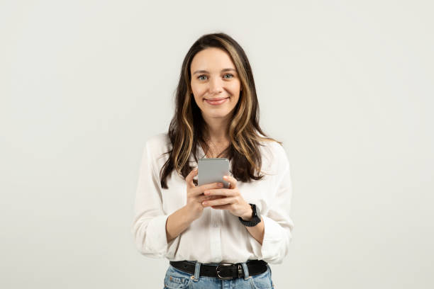 istock Content woman looking at her smartphone, potentially reading a message 2103843573