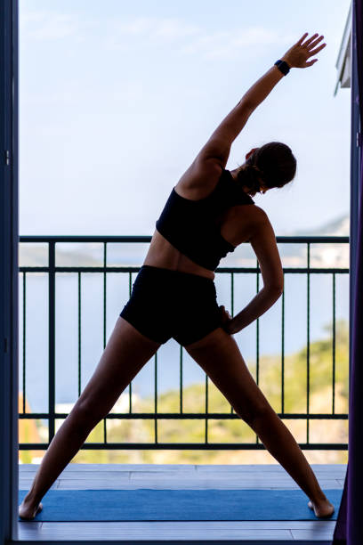 istock Young woman doing her morning exercise routine at the balcony in the morning. 2103854412