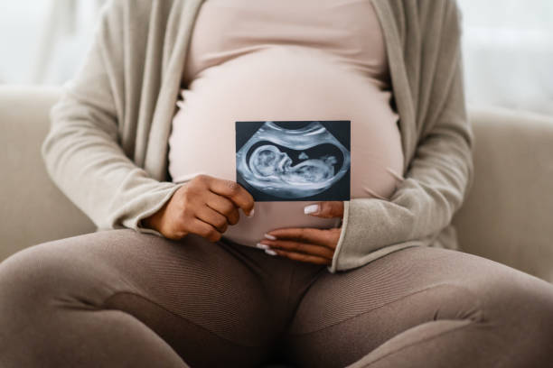 istock Unrecognizable african american expecting woman holding sonogram 2103864913