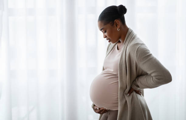 istock Side view african american expecting lady standing next to window 2103865460