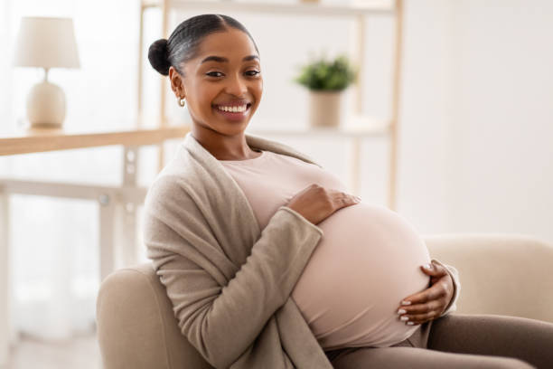 istock Side view of african american expecting lady sitting on couch 2103865484
