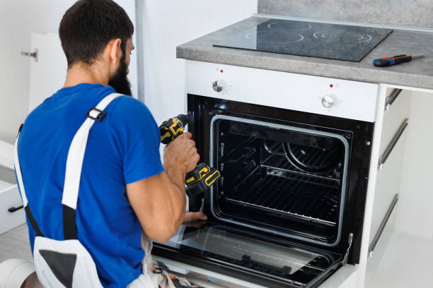 istock Man installs the oven after assembling the kitchen and screws the bolts with a screwdriver. 2103868132