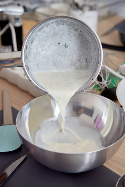 istock Pouring Cream Mixture with Vanilla into Bowl 2103881312
