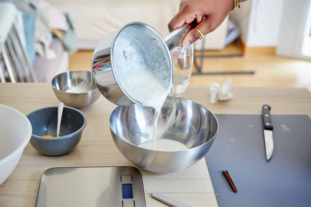 istock Black Hand Pouring Cream Mixture into a Bowl 2103881316