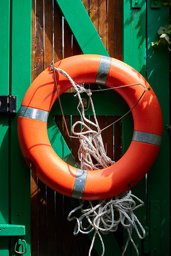 Orange Life Vest on Green Wooden Fence