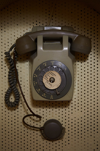 Old Brown Telephone on Peg Board Wall