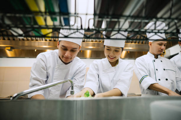 istock Two Asian Chef Washing Fresh Vegetables Learning Healthy Food In Kitchen. 2103886518