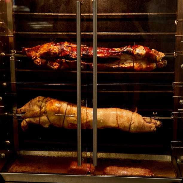A close-up view of a whole pig being roasted on a spit, showcasing the traditional method of preparing “lechon,” a popular dish in Cebu, Philippines. The golden, crispy skin glistens as it slowly cooks over an open fire, capturing the essence of Filipino culture and cuisine. This image highlights the vibrant food traditions of the Philippines, often prepared for festive occasions and celebrations.